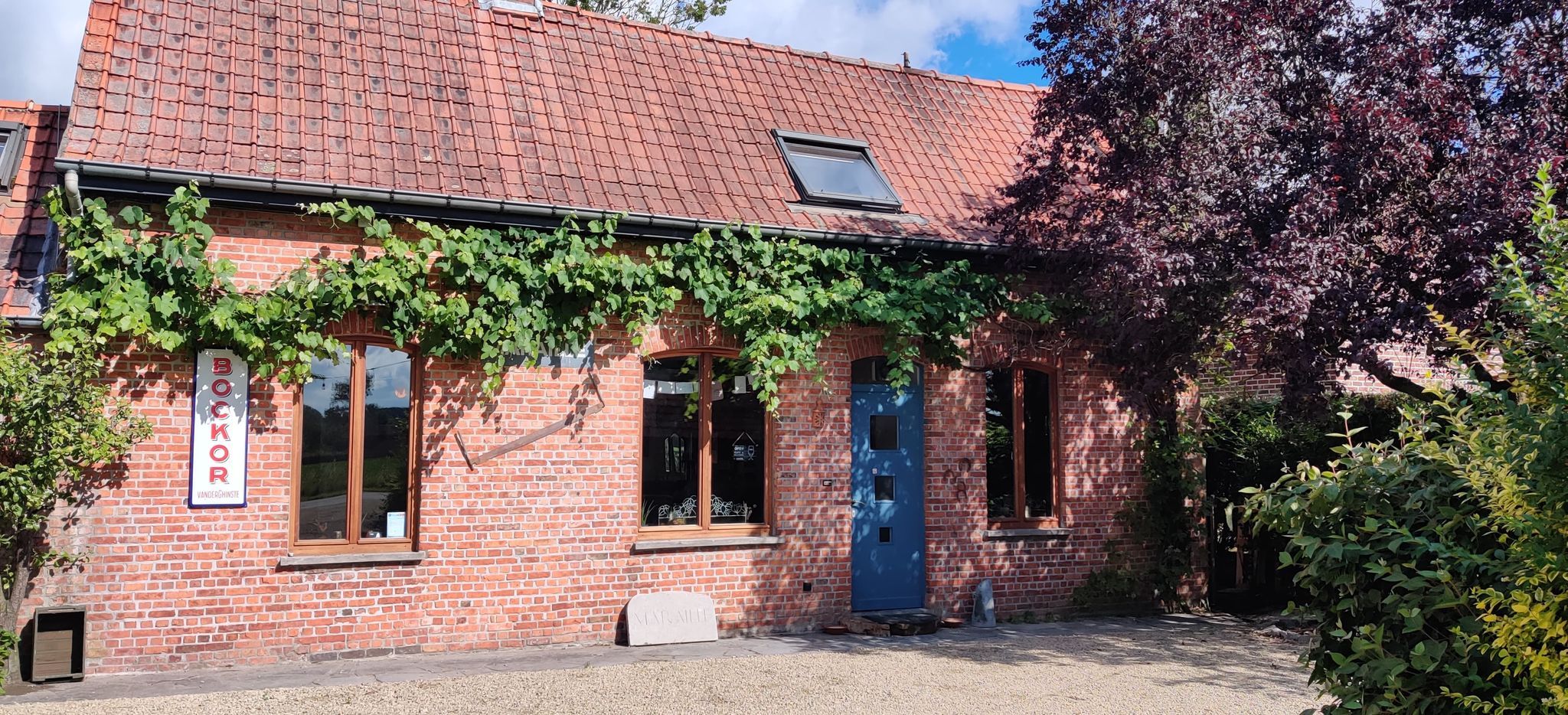 De gevel van praatcafé Maraille met groen errond.